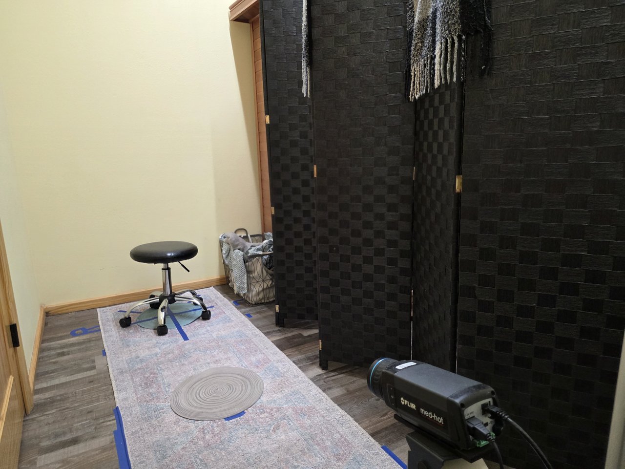 Thermal camera, marked positioning area, and stool in the imaging room.